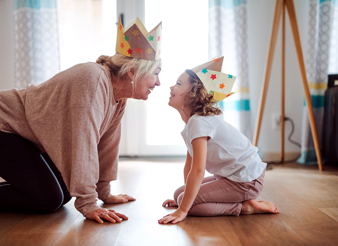 We Are Independent - Portrait of a Cheerful Grandmother and Granddaughter Wearing Crowns Having Fun Playing Together at Home